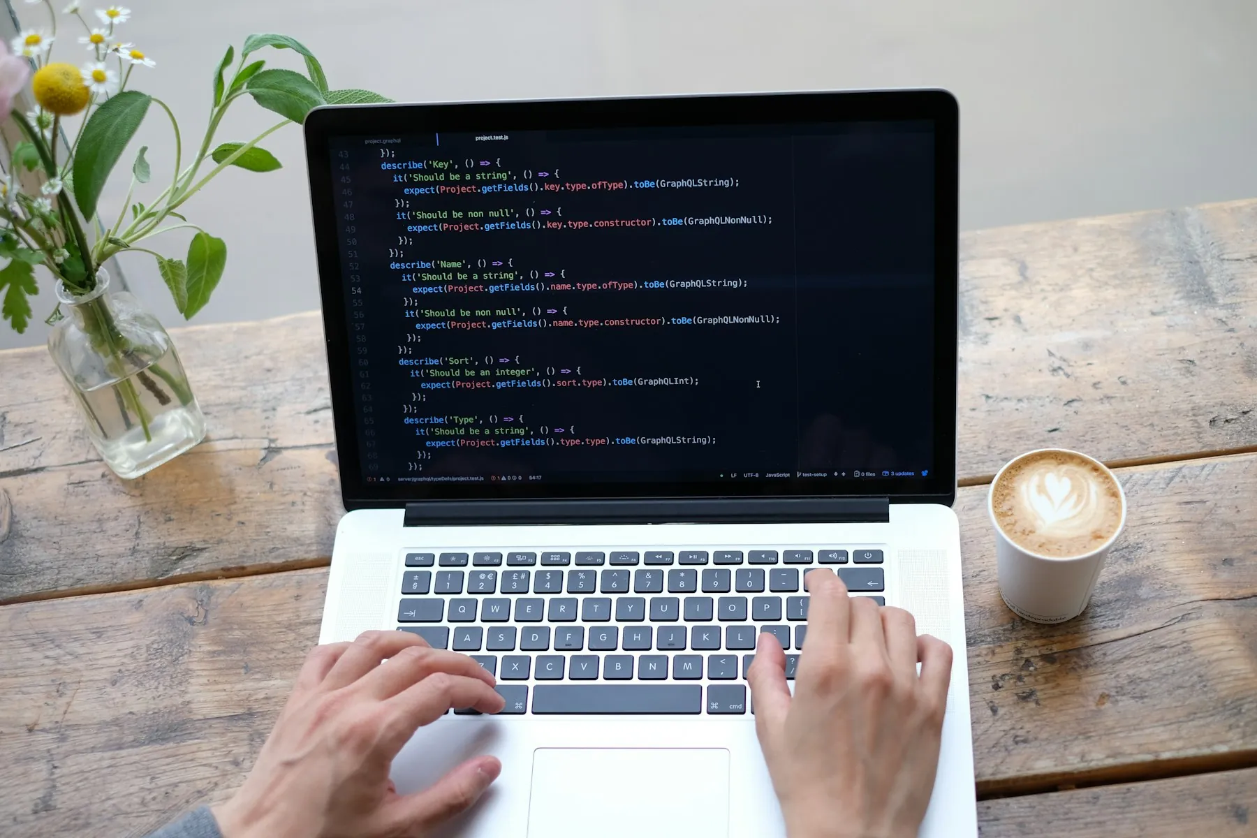 Working from a café: laptop with code on the screen and a cup of coffee